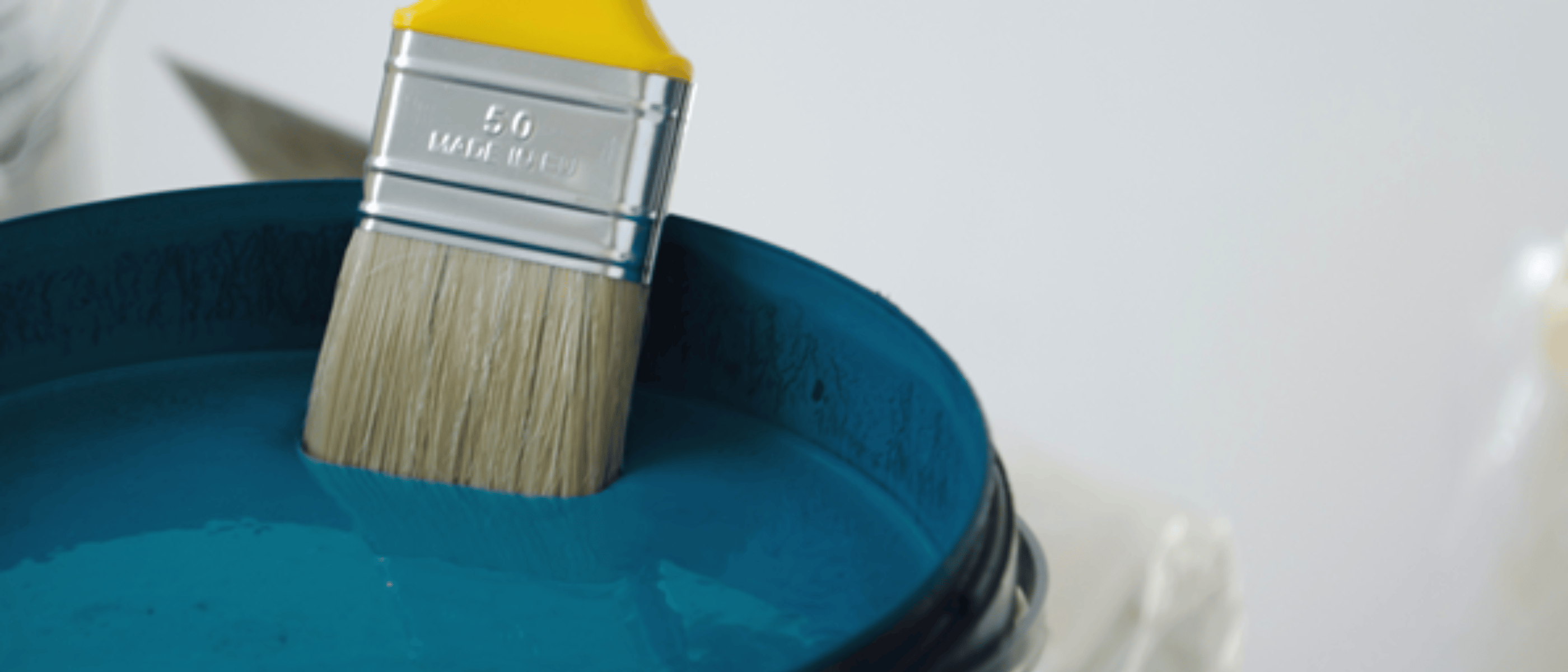 paint brush in blue paint bucket