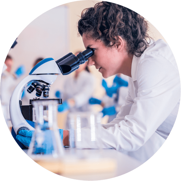 woman looking through microscope