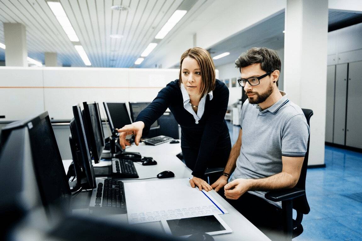 woman and man in office looking at a computer